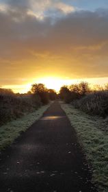 Sun rising over disused single track railway line converted to a public access path in Bridge of Weir, Renfrewshire.