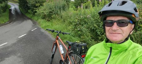 The Reluctant Cyclist - author in cycling gear, beside his bike in the Scottish countryside.